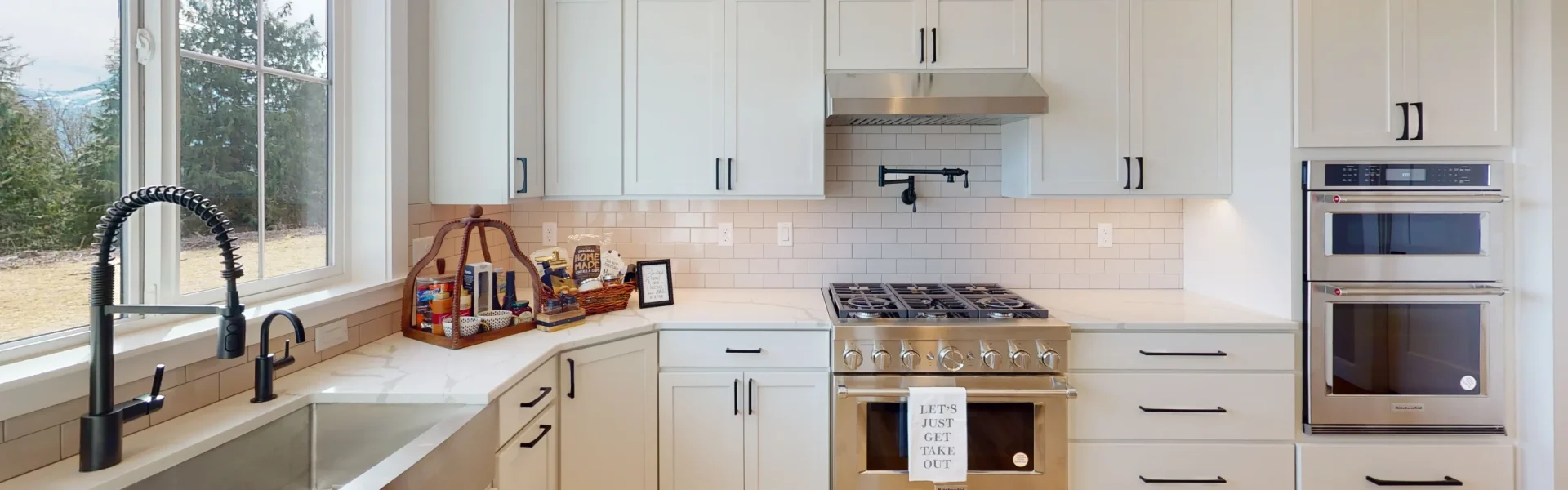 Photo of a gourmet kitchen with full height white cabinets in a custom build Lexar home