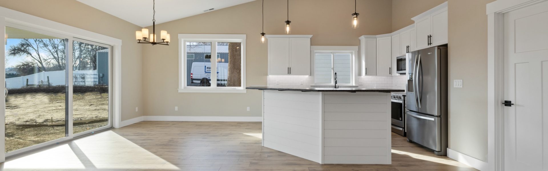 Looking into a kitchen with curved island and open dining nook area