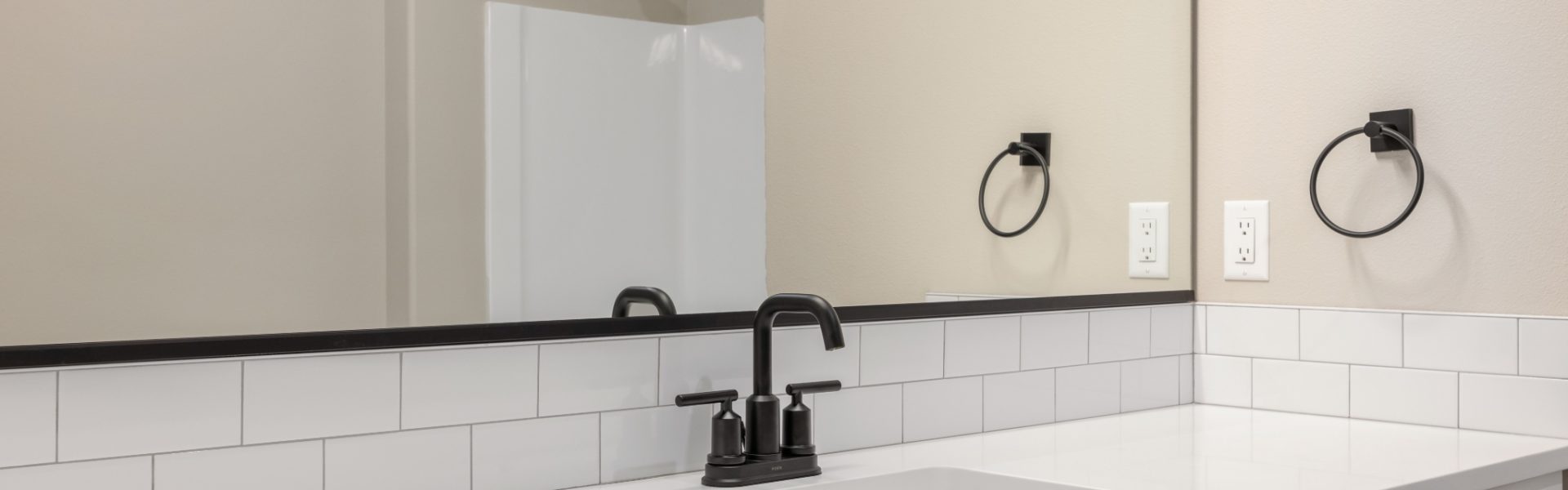 Close up photo of single sink with white counter tops